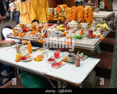 Bangkok Thailand - August 10 2007; buddhistische Gläubige bieten Tabelle mit Überbleibendes bedeckt, Nahrung, Blumen anziehen Insekten. Stockfoto