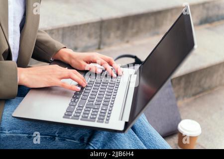 Nahaufnahme der Hände einer Frau, die an ihrem Laptop arbeitet Stockfoto
