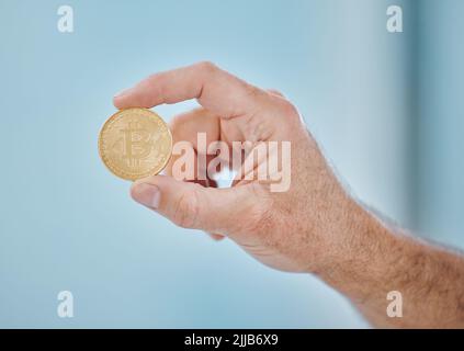 Die Zukunft liegt in Bitcoin. Ein nicht erkennbarer Geschäftsmann hält eine Bitcoin im Büro. Stockfoto