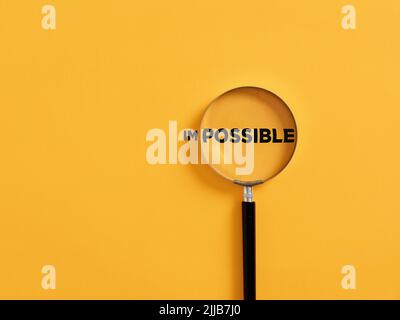 Die Lupe konzentriert sich auf die mögliche Seite des Wortes unmöglich. Es ist möglich, motivierende inspirierende Konzept. Stockfoto