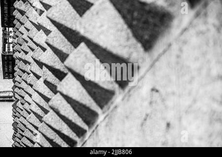 Detail der pyramidenförmigen Granitformen an der Fassade von La Casa de los Picos mit dem Balkon im Hintergrund Stockfoto