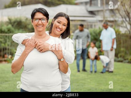 Suchen Sie nach ihnen und genießen Sie ihren Reichtum. Eine Mutter und eine Tochter halten sich gegenseitig draußen. Stockfoto