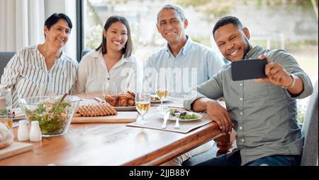 Eine Familie, die ein Selfie macht, während sie zu Hause zu Mittag essen. Stockfoto