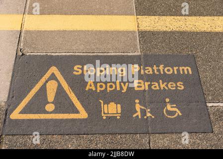 St Erth, Cornwall, England, Großbritannien. 2022. Warnzeichen einer schrägen Plattform für Passagiere, die Rollstühle, Trolleys und Kinderwagen in St. Erth benutzen Stockfoto