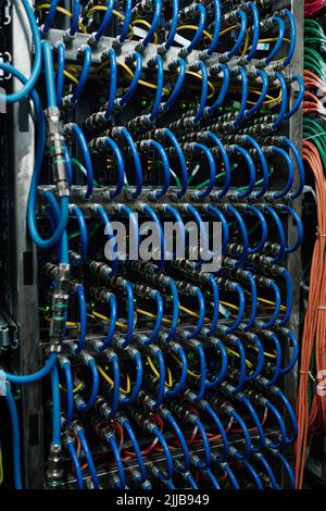 Nahaufnahme der miteinander verbundenen Internetkabel im offenen Server im Rechenzentrum Stockfoto