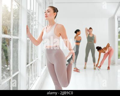 Liebe alles, was Sie sind. Eine schöne junge Frau Stretching während ihres Trainings. Stockfoto