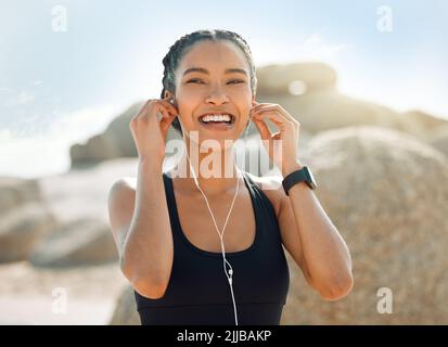 Dieser Lauf wird unglaublich. Eine junge Frau hört während eines Trainings Musik. Stockfoto