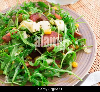 Gemischter Salat aus Rucola und frischem Gemüse mit Sauce Stockfoto