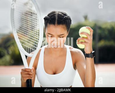 Es geht darum zu glauben, dass Sie gewinnen werden. Eine sportliche junge Frau spielt Tennis auf einem Platz. Stockfoto