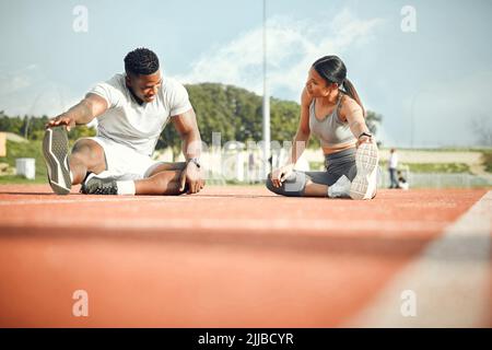 Du bist bereit. Ganzkörperaufnahme eines jungen, sportlichen Paares, das sich vor dem Start der Outdoor-Übung aufwärmt. Stockfoto