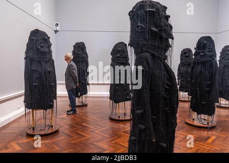 Adelaide; Australien 25. Juli 2022. Eine Staffel anthropomorpher Skulpturen der Canberra-Künstlerin Heather B. Swann (geb. Hobart Australia 1961) tragbarer Skulpturen von riesigen dunklen und brütenden Banksia Men, die sich mit der Natur beschäftigen, und auch auf die schurkischen Figuren aus Erzählungen des australischen Kinderautors May Gibbs hinweisen, die in der Kunstgalerie von South Australia ausgestellt sind. Kredit. amer Ghazzal/Alamy Live Nachrichten Stockfoto