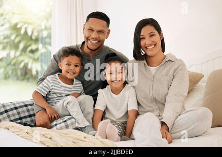 Waren nur zum Abkühlen da. Porträt einer schönen jungen Familie, die im Bett miteinander redet und sich verbindet. Stockfoto