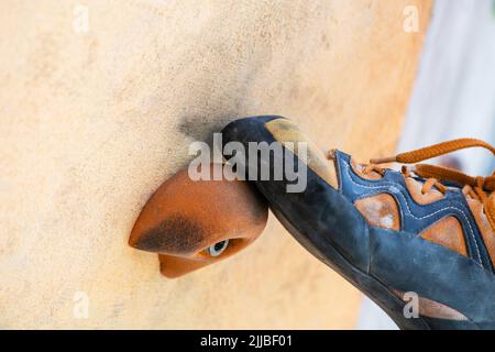 Nahaufnahme des Kletterschuhetrainings in künstlicher Kletterwand im Freien. Kletterdetails. Stockfoto