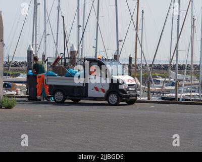 Breskens, Niederlande, 18. Juli 2022, man leert den Müll und sammelt den Müll am Kai der Marina in Breskens Stockfoto