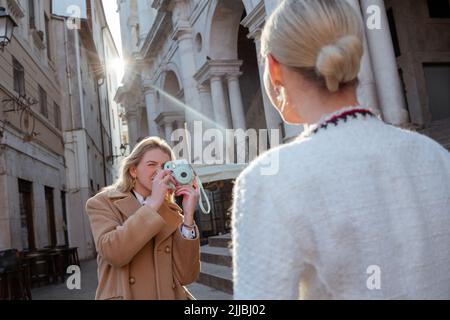 Konzentrierter Fotograf, der Bilder von einer Frau fotografiert Stockfoto