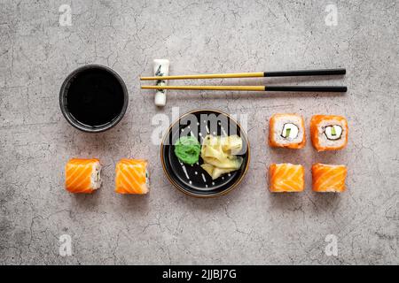 Sushi-Brötchen mit Lachs auf dem Tisch, Draufsicht Stockfoto