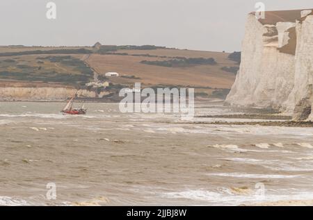 Cuckmere Haven , East Sussex, Großbritannien. Sea Rescue verlassene Boot, Cuckmere Haven, East Sussex, Großbritannien. Das Segelboot The Cape Michelle liegt auf den Felsen unter dem rauen Grund zwischen Cuckmere Haven und Birling Gap. Das RNLI-Rettungsboot, das in Newhaven, dem Hubschrauber der Küstenwache, gegen 6,45 Uhr stationiert war, rettete die ein-Mann-Besatzung, die sich jetzt in Isolation befindet. Das in Kingston upon Hull registrierte Schiff aus dem Jahr 16m bleibt auf dem Boden, während die Flut eintrifft und es gegen die Kreidefelsen schlägt. Cuckmere Haven, East Sussex, Großbritannien. Stockfoto