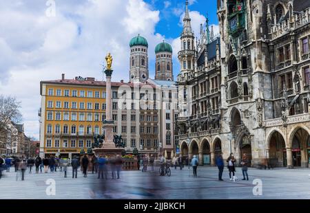 MÜNCHEN, DEUTSCHLAND - MAI 4 2022 : Menschen gehen auf dem Marienplatz in der Stadt. Durch lange Belichtung verblichtet. Stockfoto