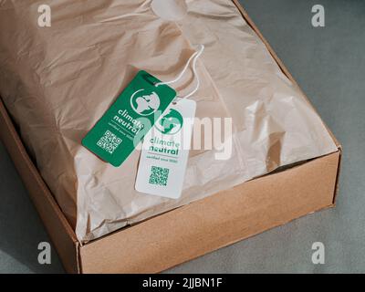 Klimaneutrales Produkt in Craft-Wellpappe mit Etikett Klimaneutral. Klimaneutrales Label-Konzept in den Bereichen Bekleidung, Mode, Logistik und ethischer Konsum. Erhöhung des Bewusstseins für Kunden über CO2-Fußabdruck Stockfoto