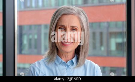 Porträt einer lächelnden selbstbewussten 60-er grauhaarigen reifen Frau. Stockfoto