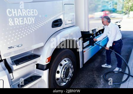 25. Juli 2022, Rheinland-Pfalz, Wörth am Rhein: Ein Mitarbeiter demonstriert bei der Eröffnung des neuen Netz BW und Daimler Truck Demo-Ladeparks, wie man einen Lkw im Mercedes-Benz Trucks Kundencenter lädt. Im neuen Kunden-Demo-Park können Besucher ab dem 1. August 2022 Ladesäulen und Ladekonzepte für Elektro-Lkw im realen Betrieb testen. Foto: Uwe Anspach/dpa Stockfoto