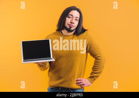 Eine langhaarige Person mit einem Bart in einem Raum, in dem ein Notizbuch steht, und einem Blick in die Linse in einem Raum auf einem orangefarbenen Hintergrund. Hochwertige Fotos Stockfoto