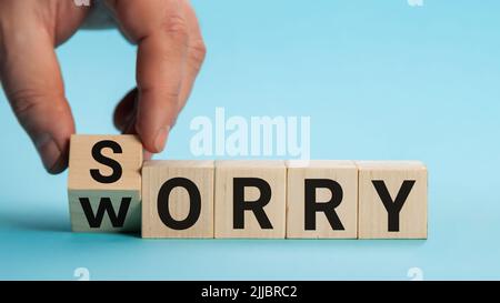 Es tut uns leid, uns Sorgen zu machen Hand dreht einen Würfel und ändert das Wort Sorge in Entschuldigung. Geschäftskonzept, Kopierbereich. Stockfoto