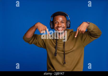 Sie sind dran. Lustiger afrikanischer Mann, der mit den Fingern auf die Kamera zeigt, die im Studio posiert Stockfoto