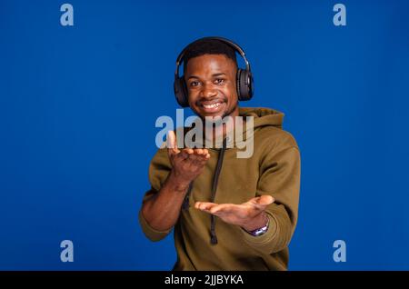 Sie sind dran. Lustiger afrikanischer Mann, der mit den Fingern auf die Kamera zeigt, die im Studio posiert Stockfoto