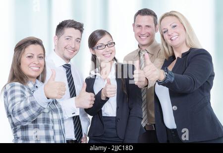 Ein erfolgreiches Business-Team zeigt Daumen nach oben Stockfoto