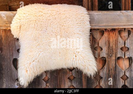 Schafshaut auf einem Holzzaun in ländlicher Umgebung. Reise-, Tourismus- und Umweltkonzept. Stockfoto