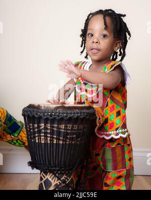 Traditionelle Ghanaische Mode. Helle Kente-Stoffe aus Ghana, Westafrika, die von unbeschwerten jungen ghanaischen Kindern modelliert wurden. Teil einer Serie. Stockfoto