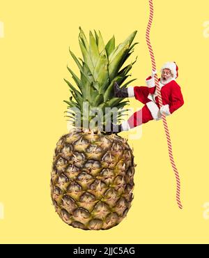 Collage zeitgenössischer Kunst. Kreatives Design mit fröhlichem älteren Mann im Bild des Weihnachtsmanns, der auf Ananas das Seil hochklettert Stockfoto