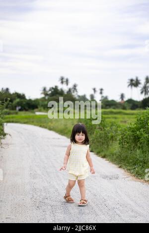 Nettes kleines Mädchen, das die Natur des Reisfeldes erkundet. Begeistert für das Abenteuer. Stockfoto