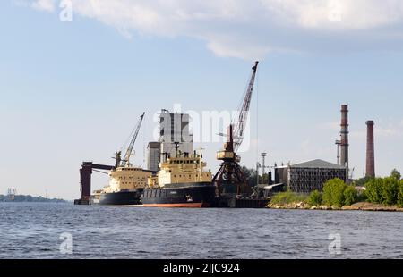 Riga Hafen oder Riga Docks, ein ostseehafen, mit festfahrenden Industriefrachtschiffen und Kränen, an der Daugava, Riga Lettland Europa Stockfoto