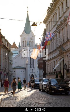 Straßenszene in Riga; Menschen, die zur Kirche der Schmerzensmutter, Pils Iela, Rigaer Altstadt, Riga Lettland Europa gehen Stockfoto