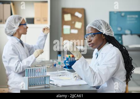 Portrait einer Laborantin, die am Teststandort Experimente mit Flüssigkeit durchführt Stockfoto