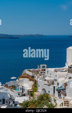 OIA, GRIECHENLAND - MAI 22,2022: Traditionelle weiße Häuser mit kleinem Pool in Oia, Santorini, Griechenland Stockfoto