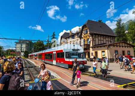 Hohe Tatra, Slowakei - Juli 2018: Der Zug der Tatra Electric Railways (TEZ-TER) (auch bekannt als Tatra Tram) hält am Bahnhof Stary Smokovec in der Hohen Tatra Stockfoto