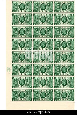Ein Block von grünen George V Mint Vintage GB-Marken auf weißem Hintergrund. Stockfoto