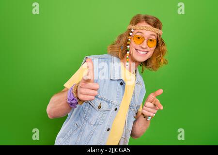 Foto von fröhlichen lustige Person zeigen Finger Kamera Sie toothy Lächeln isoliert auf grünem Hintergrund Stockfoto