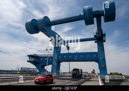 Wolgast, Deutschland. 25.. Juli 2022. Autos fahren über die Peenebrücke in Wolgast auf die Insel Usedom. Mehrmals täglich öffnet sich die kombinierte Eisenbahn- und Straßenbrücke zur Insel Usedom, um die Schifffahrt in die Ostsee zu ermöglichen. Quelle: Stefan Sauer/dpa/ZB/dpa/Alamy Live News Stockfoto