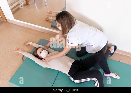 Draufsicht eines Arztes, der in einer Reha eines Patienten arbeitet Stockfoto
