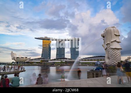 Singapur - 21. Juli 2022: Merlion-Statue-Brunnen, Marina Bay Sands Gebäude und ArtScience Museum mit Langzeitbelichtung aufgenommen. Stockfoto