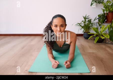 Eine multiethnische Frau blickt direkt nach vorne, während sie sich vom Unterarm nach oben ruht Stockfoto