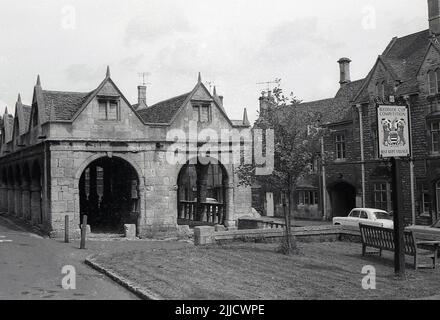 1970s, historische Ansicht der alten Markthalle im Cotswold-Dorf Chipping Campden, mit Schild auf dem Postweg mit der Aufschrift „Bledisloe Cup Compeition, Best Kept Village, Gloucestershire, England, UK. Der Wettbewerb „Best Kept Village“ wurde 1937 gestartet und war nach Sir Charles Bathurst, Viscount (Lord) Bledisloe von Lydney, als „Bledisloe Cup“ bekannt. Der Wettbewerb wurde vom Council for the Preservation of Rural England organisiert. Die aus Stein erbaute alte Markthalle wurde 1627 von Sir Baptist Hicks als Ort für den Handel mit frischen Lebensmitteln und Fleisch errichtet. Stockfoto