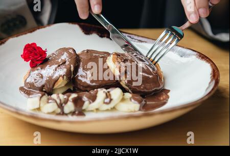 Nahaufnahme, leckere Pfannkuchen mit Schokolade und Banane zum Frühstück. Stockfoto