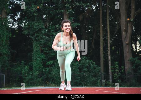 Attraktive junge Frau beim Joggen im Stadion. Stockfoto