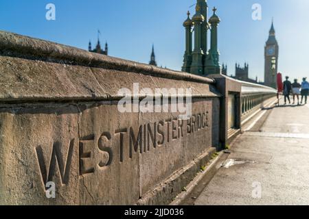 Anonyme Touristen, die über die Westminster Bridge in Richtung Houses of Parliament und Big Ben in London, England, laufen Stockfoto