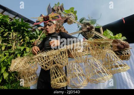 Bogor, Indonesien. 24.. Juli 2022. Ein Mann in Naturkleid aus Blättern, Blumen, Wurzeln nimmt am 24. Juli 2022 an einer Naturmodeparade 'Zurück zur Kulturerhaltung der Natur' in Bogor, West Java, Indonesien Teil. (Foto von Andi M Ridwan/INA Photo Agency/Sipa USA) Quelle: SIPA USA/Alamy Live News Stockfoto